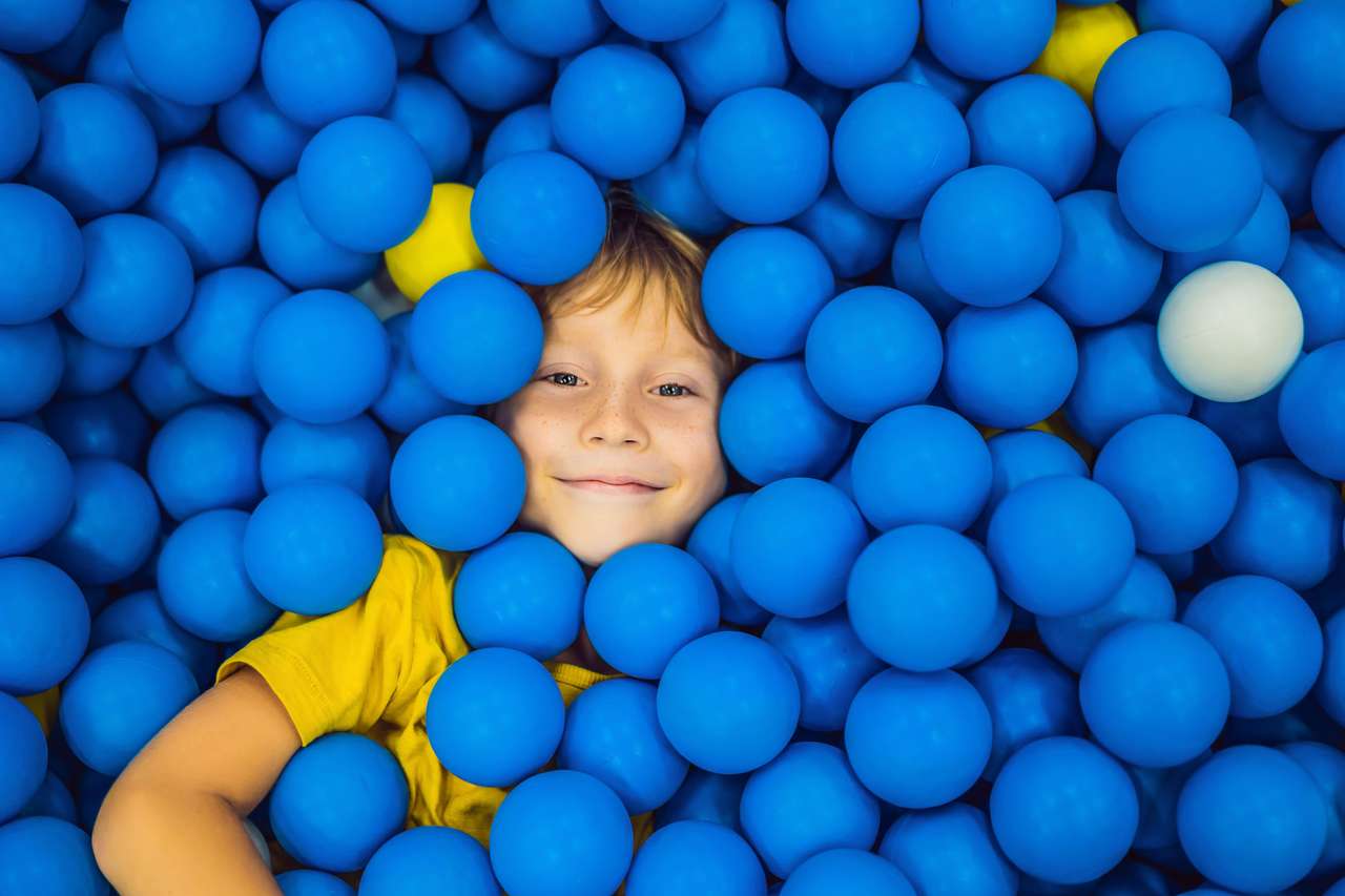 Ребенок играет в яме с шариками пазл онлайн