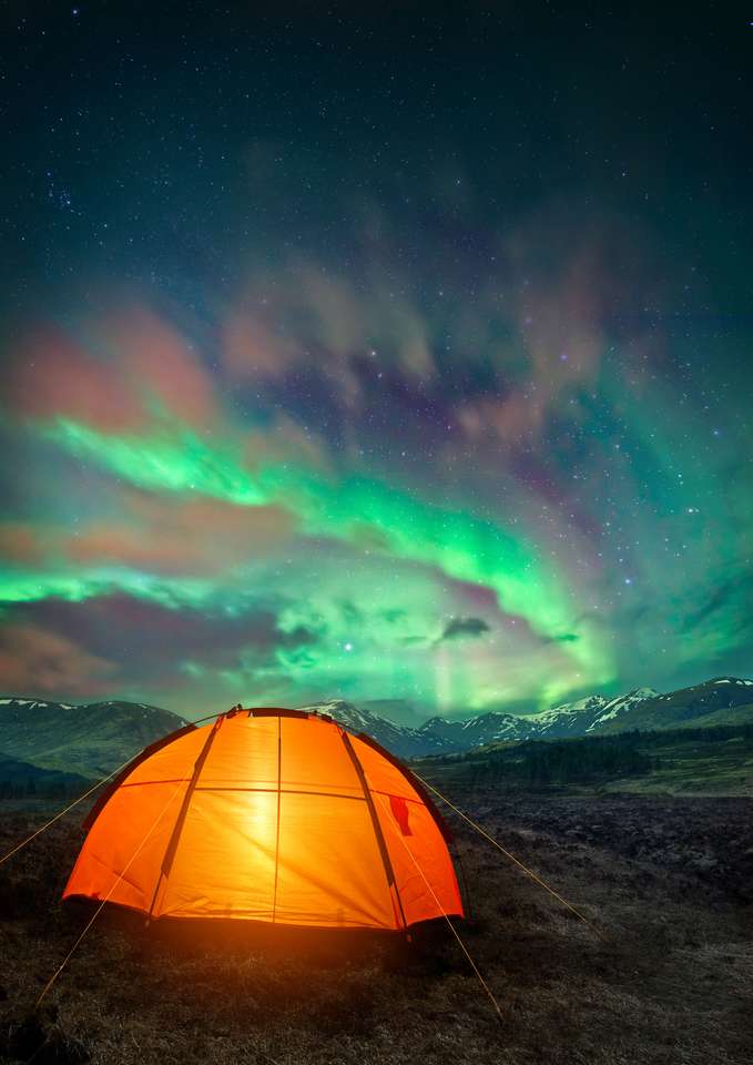 Ett campingtält som glöder under norrskenet Pussel online