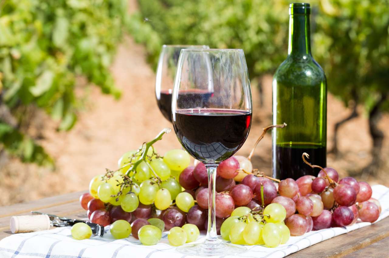Üveg vörösbor és érett szőlő az asztalon online puzzle