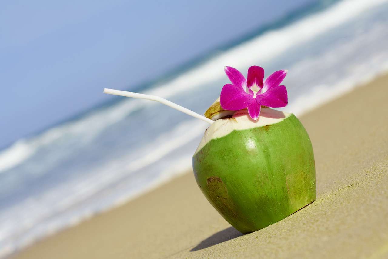Weergave van mooie verse tropische cocktail versierd met orchidee op zandig strand online puzzel