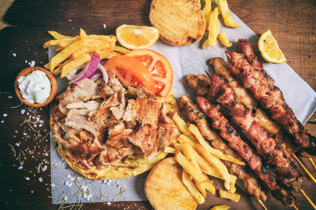 Греческое блюдо из гироса и мясные шашлычки на деревянном фоне онлайн-пазл