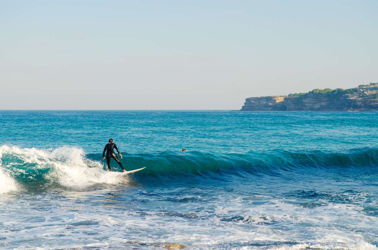 Surfers attrapant les vagues dans les eaux de Bondi Beach à Sydney Australie. puzzle en ligne