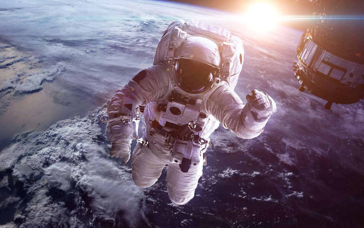 Астронавт в космоса срещу фона на планетата Земя онлайн пъзел