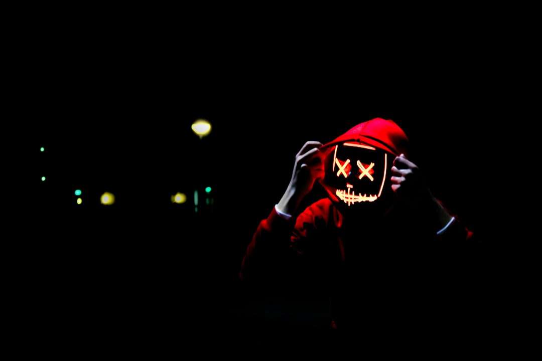 persona che indossa una felpa con cappuccio e una maschera al neon puzzle online
