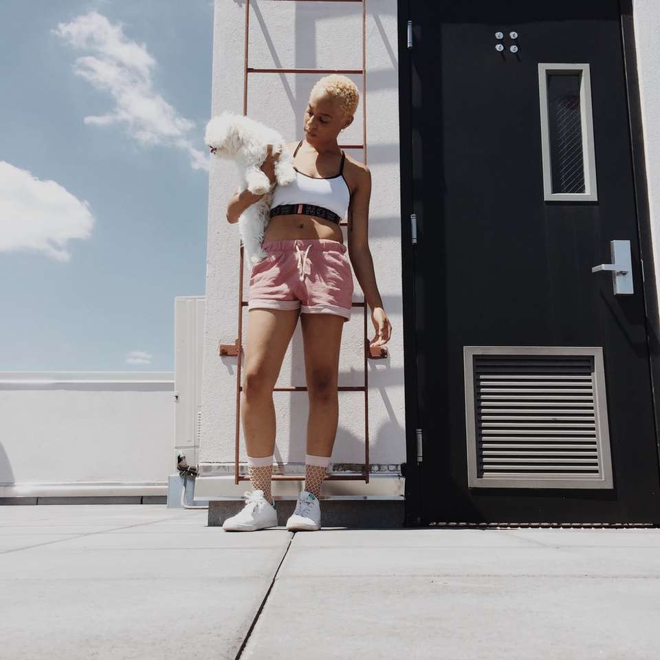 женщина держит длинношерстного щенка на крыше здания онлайн-пазл
