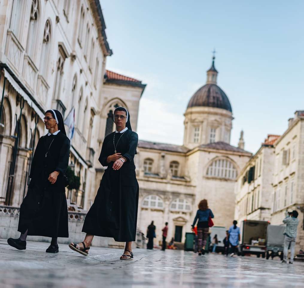 Dos monjas caminando frente a la catedral. rompecabezas en línea