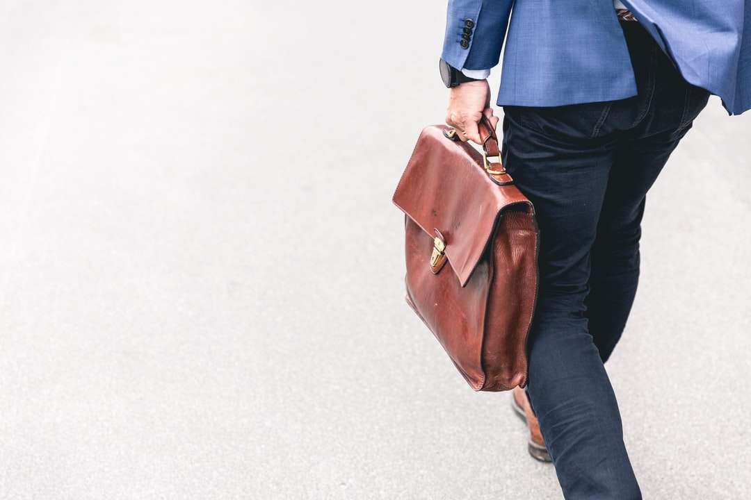 άτομο που περπατά κρατώντας καφέ δερμάτινη τσάντα online παζλ