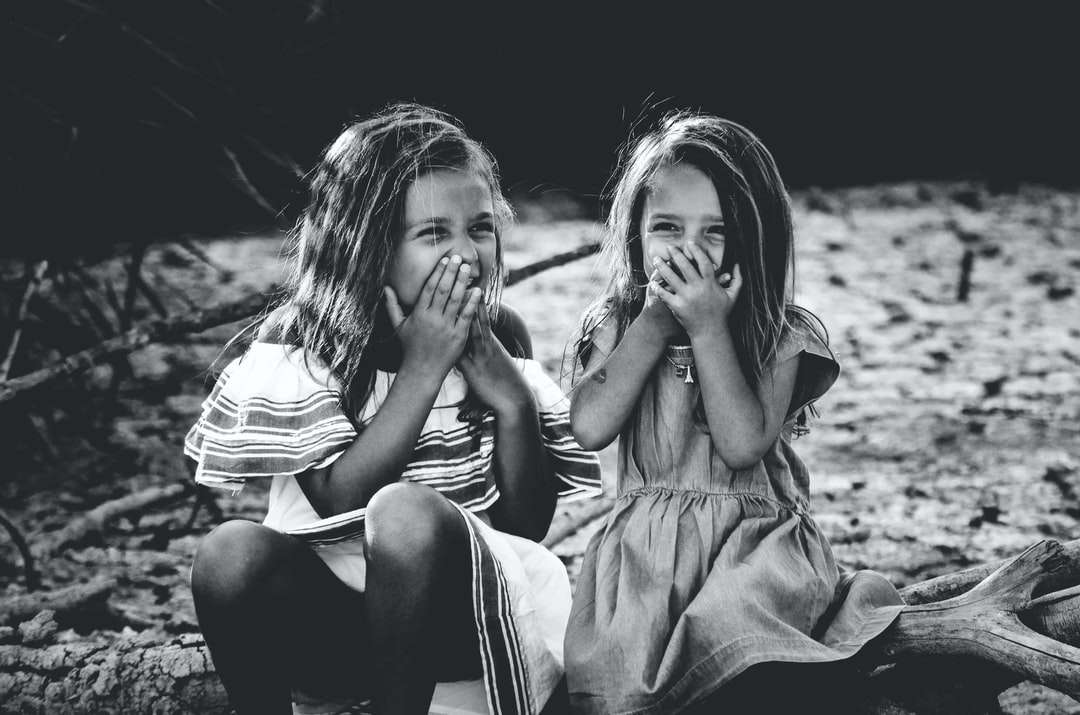 grijswaardenfotografie van twee meisjes die hun mond sluiten legpuzzel online