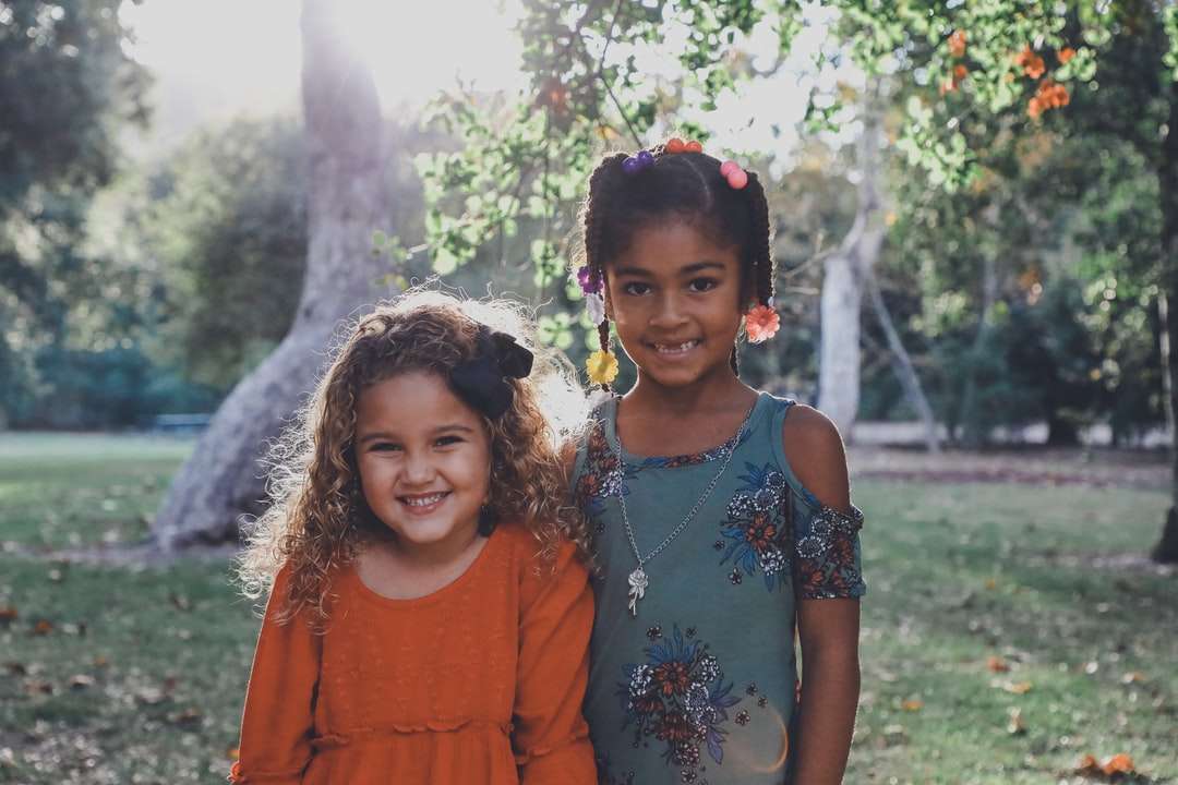 двоє одягнених дітей стоять проти дерев пазл онлайн