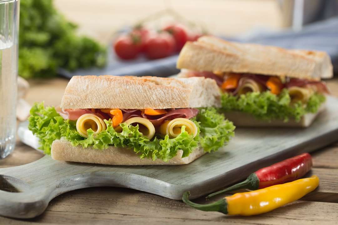 Sandwich med sallad och ost serveras på skivbräda pussel på nätet