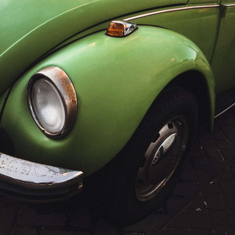 Groene Volkswagen Kever op zwarte bakstenen vloer legpuzzel online