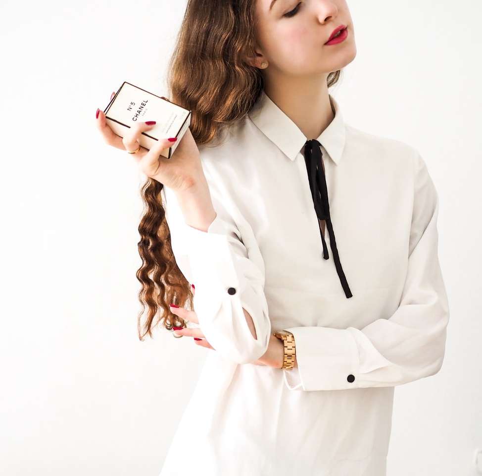 woman in white blazer holding white smartphone jigsaw puzzle online