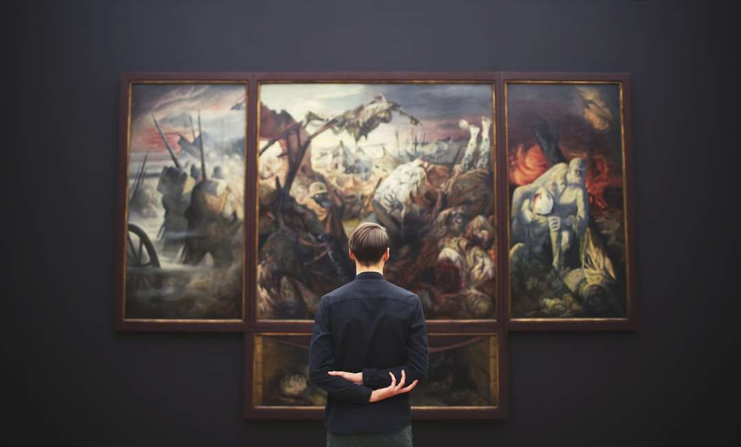 Ο άνθρωπος χέρια στην πλάτη κοιτάζοντας τη ζωγραφική τοποθετημένη στον τοίχο online παζλ