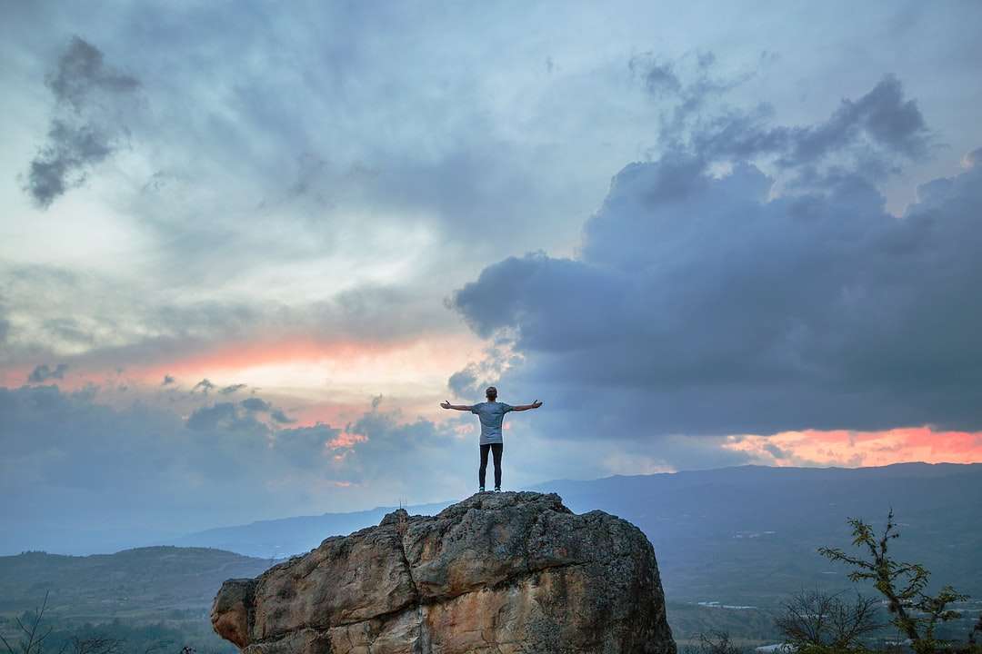 Omul stând pe vârful muntelui Rock în timpul orelor de aur jigsaw puzzle online