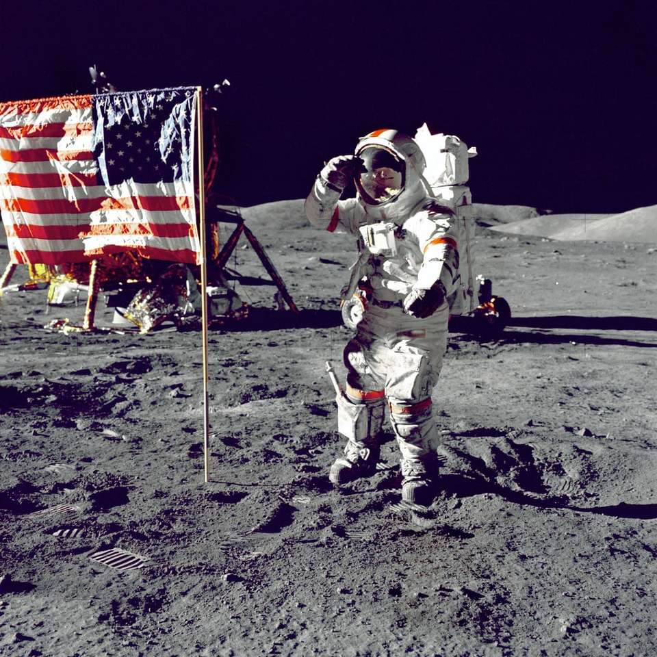 Astronaut står på månen bredvid U.S.A. flagga pussel på nätet