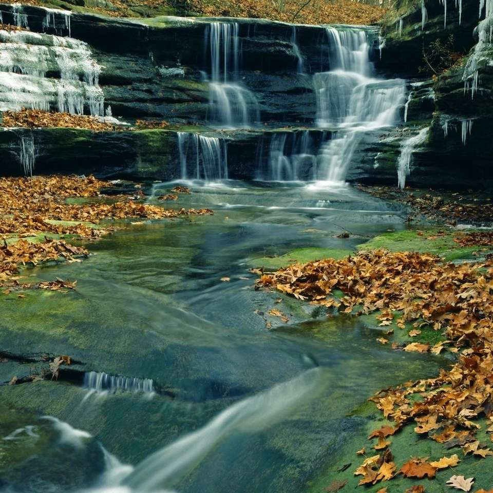 Water falling behind the rocks in autumn online puzzle
