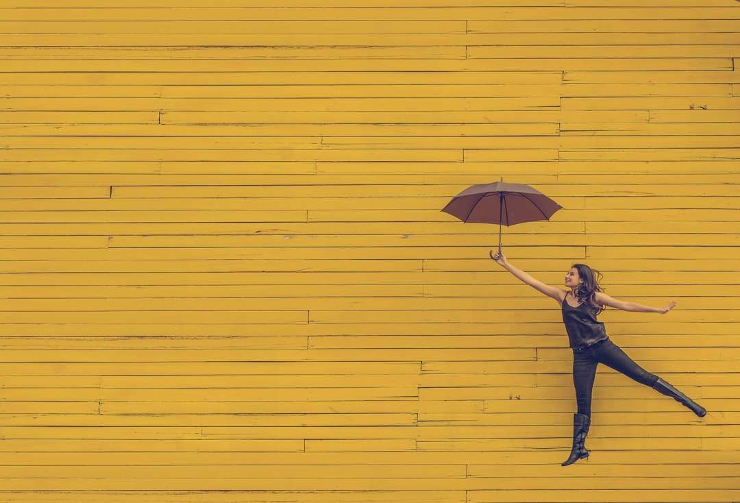femeie ținând o umbrelă maro puzzle online