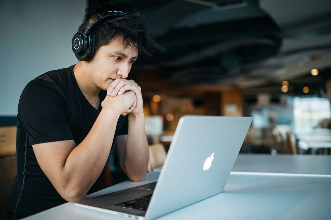мъж, който носи слушалки, докато седи на стол отпред онлайн пъзел