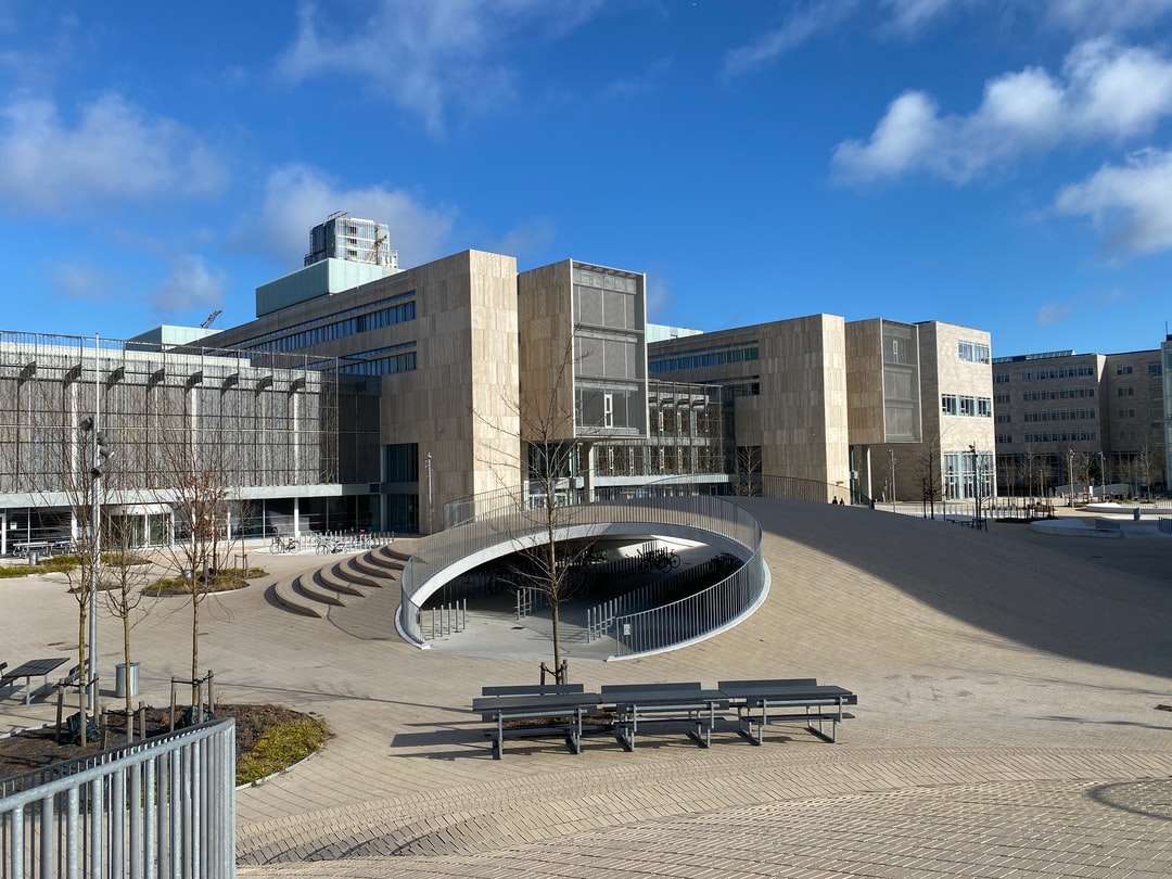 clădire din sticlă rotundă lângă clădirea de beton maro puzzle online
