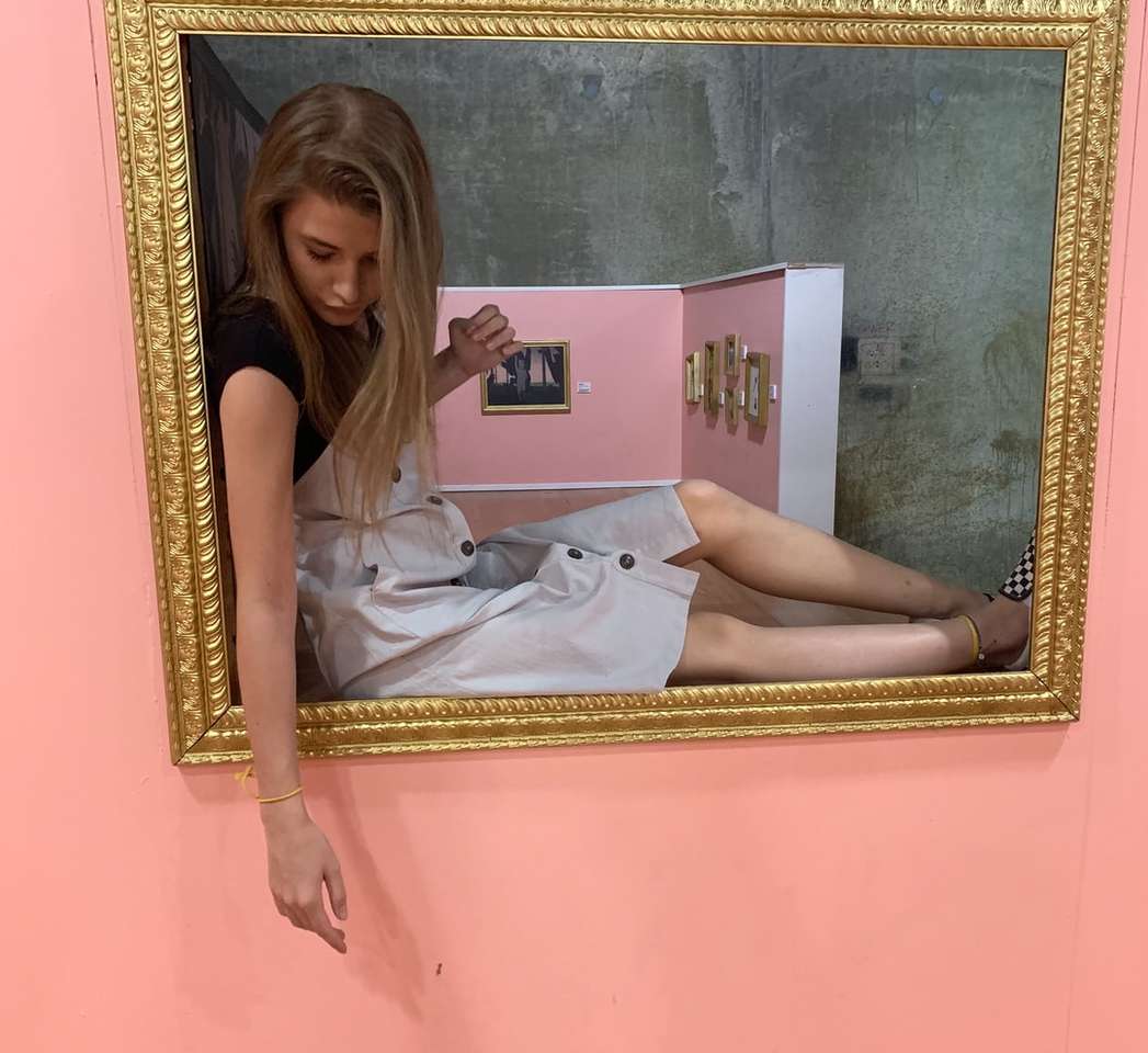 Kvinna sitter på grå och brun målning ram Pussel online