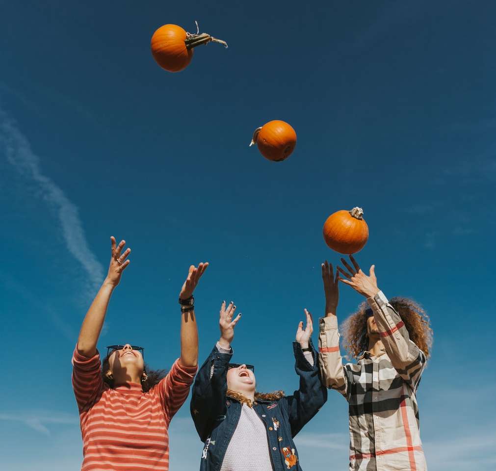 хора, държащи оранжев баскетбол под синьо небе онлайн пъзел