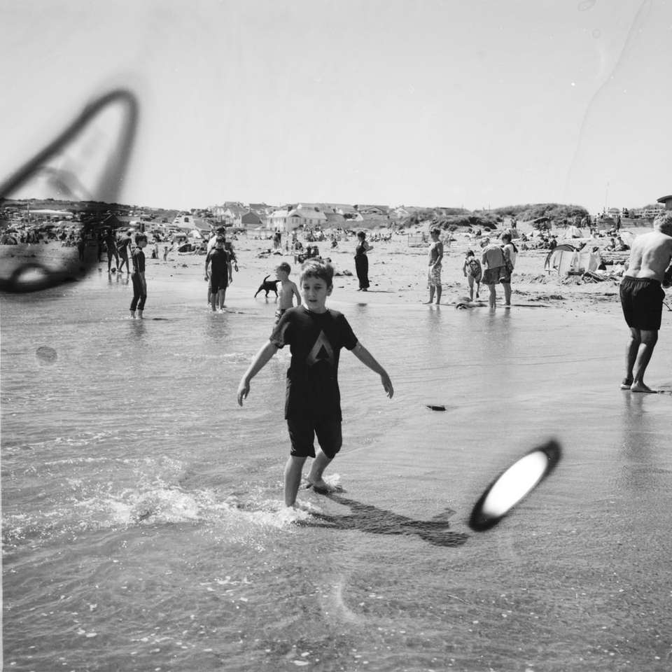 gråskalefoto av människor som leker på stranden Pussel online
