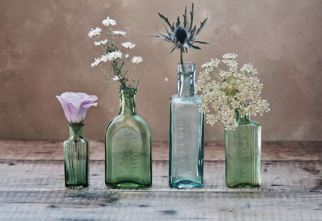 Τρία πράσινα και ένα μπλε γυαλί αγγεία με λουλούδια μέσα παζλ online