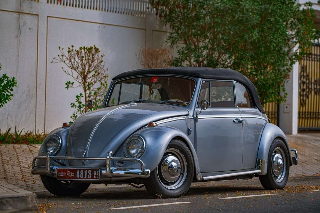 Blue Classic Auto geparkt in der Nähe von White Building Puzzlespiel online