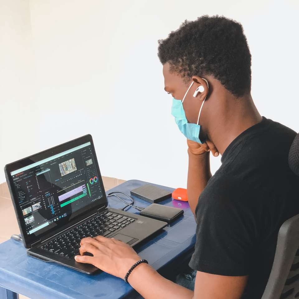 férfi fekete nyakú pólóban fekete laptop számítógépet használ online puzzle