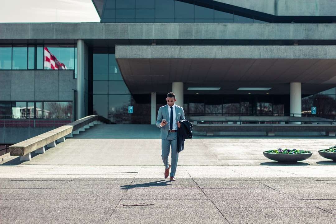 Mann zu Fuß, während er schwarzen Mantel hält Puzzlespiel online