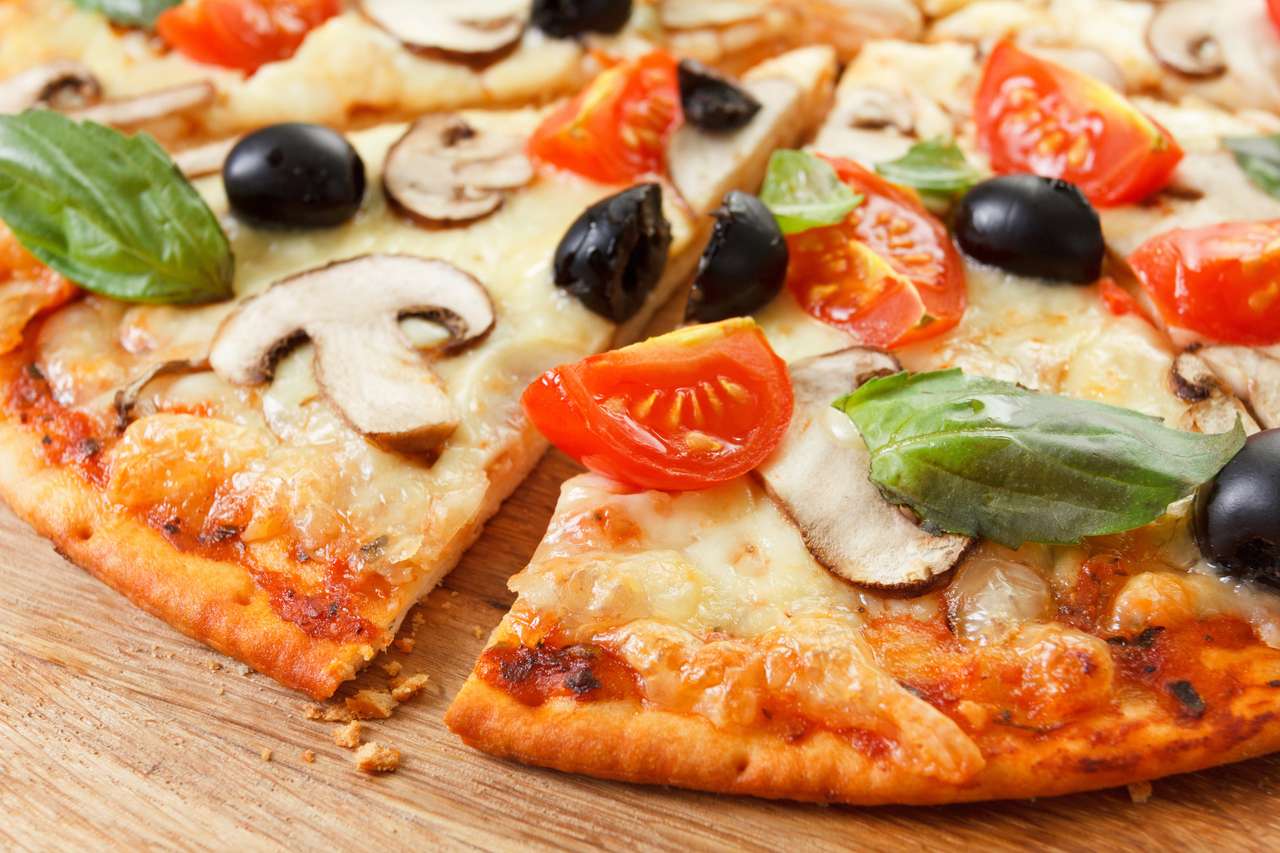 Нарезанная пицца с грибами, оливками и помидорами. Базилик, розмарин и свежие овощи. Свежий домашний онлайн-пазл