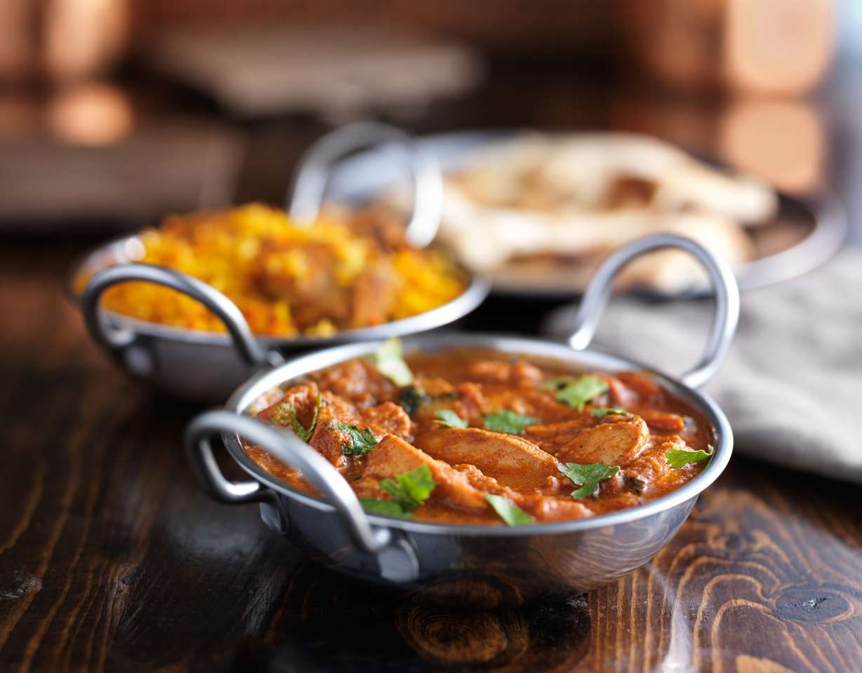 Curry de pollo de mantequilla india en plato de Balti rompecabezas en línea