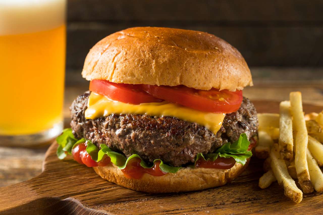 Zelfgemaakte gras gevoed cheeseburger met friet en een bier legpuzzel online