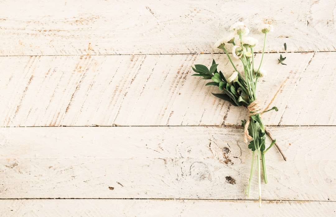 Ramo de la flor blanca en superficie de madera rompecabezas en línea