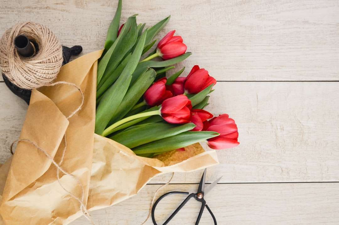 Ramo de flores de tulipán rojo en paleta de madera marrón rompecabezas en línea