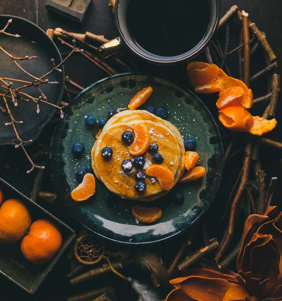 Pannkakor med apelsin och blåbär på tallrik pussel på nätet