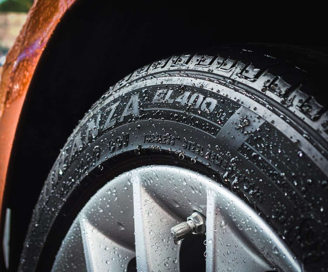 fotografia di messa a fuoco superficiale della ruota d'auto d'argento e del pneumatico dell'auto puzzle online