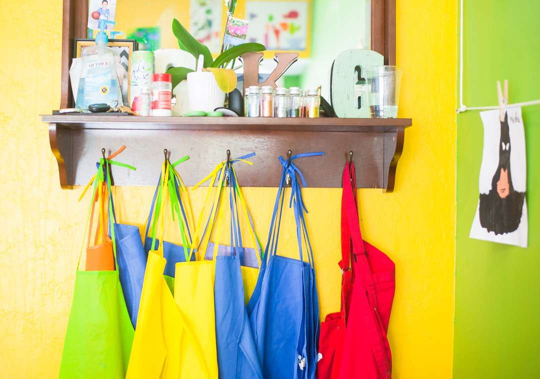 Асортирани цветови чанта Лот висящи върху кафяв дървена стена онлайн пъзел