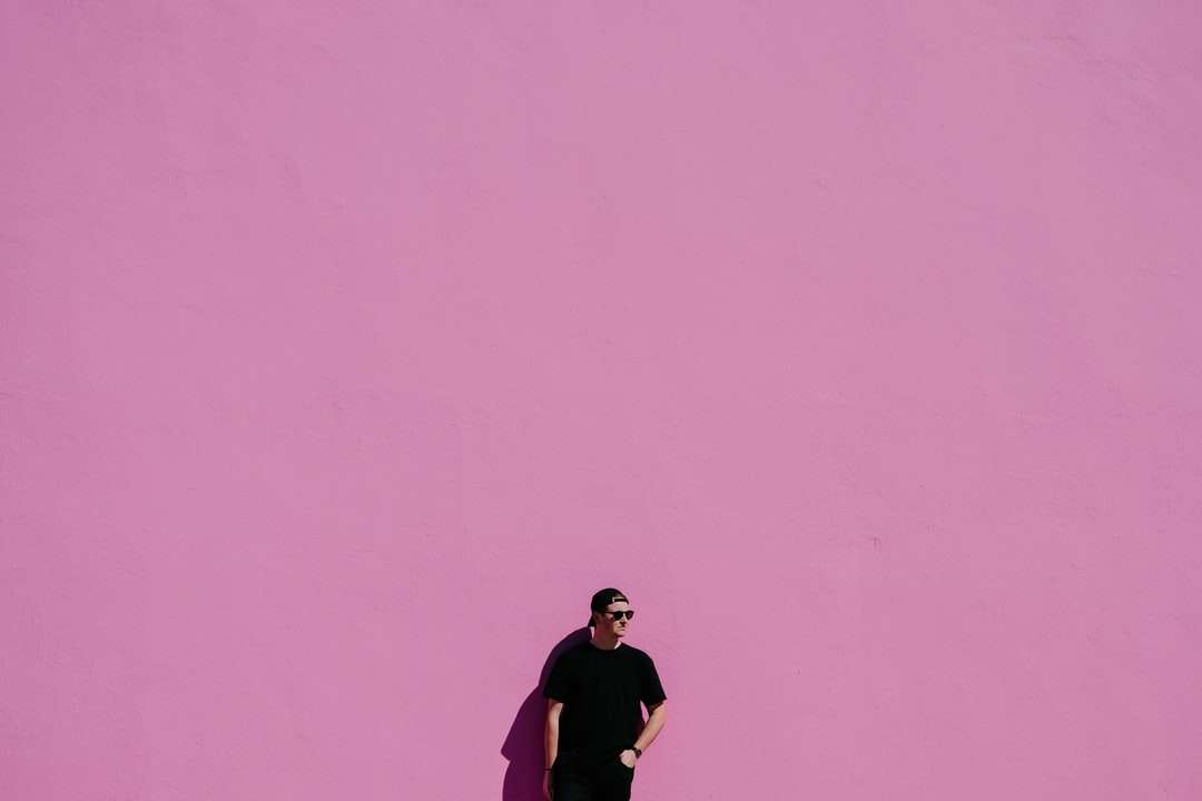 Uomo in camicia nera su sfondo rosa puzzle online