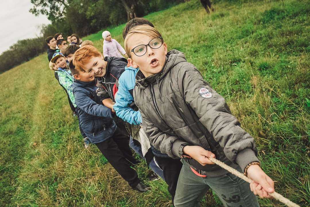 Grupp av barn som drar brunt rep pussel på nätet