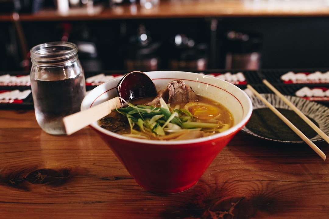 Soupe avec légumes à côté de baguettes et verre d'eau puzzle en ligne