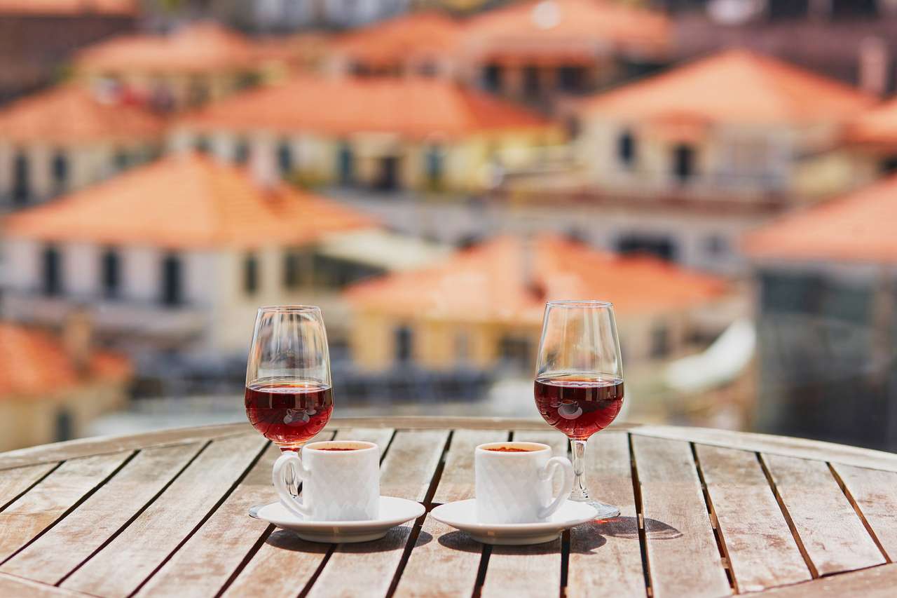 Δύο ποτήρια κρασί της Μαδέρας και δύο φλιτζάνια φρέσκο ​​καφέ εσπρέσο στο δρόμο του δρόμου με θέα στην πόλη Funchal, Μαδέρα, Πορτογαλία online παζλ
