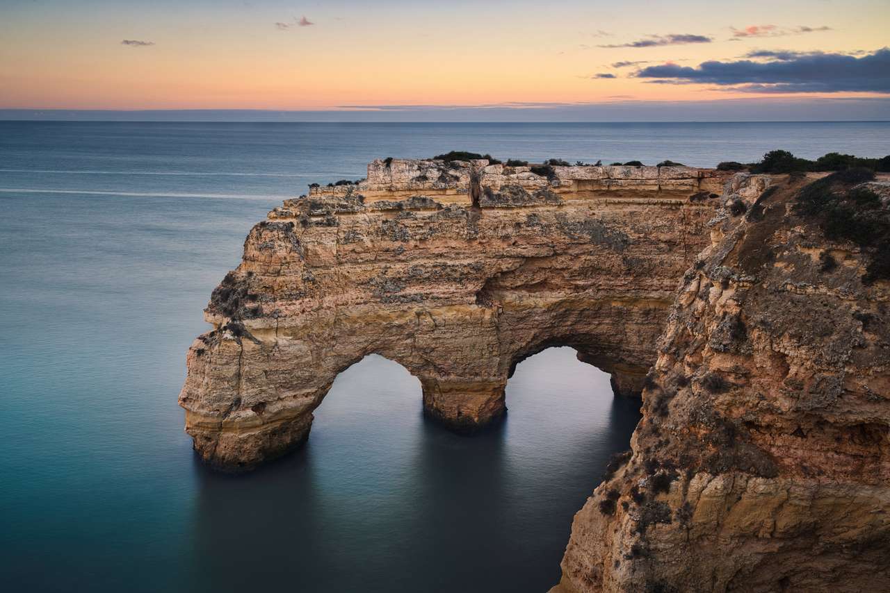 Снимка на естествената арка в Фаро Португалия при времето на залеза. онлайн пъзел