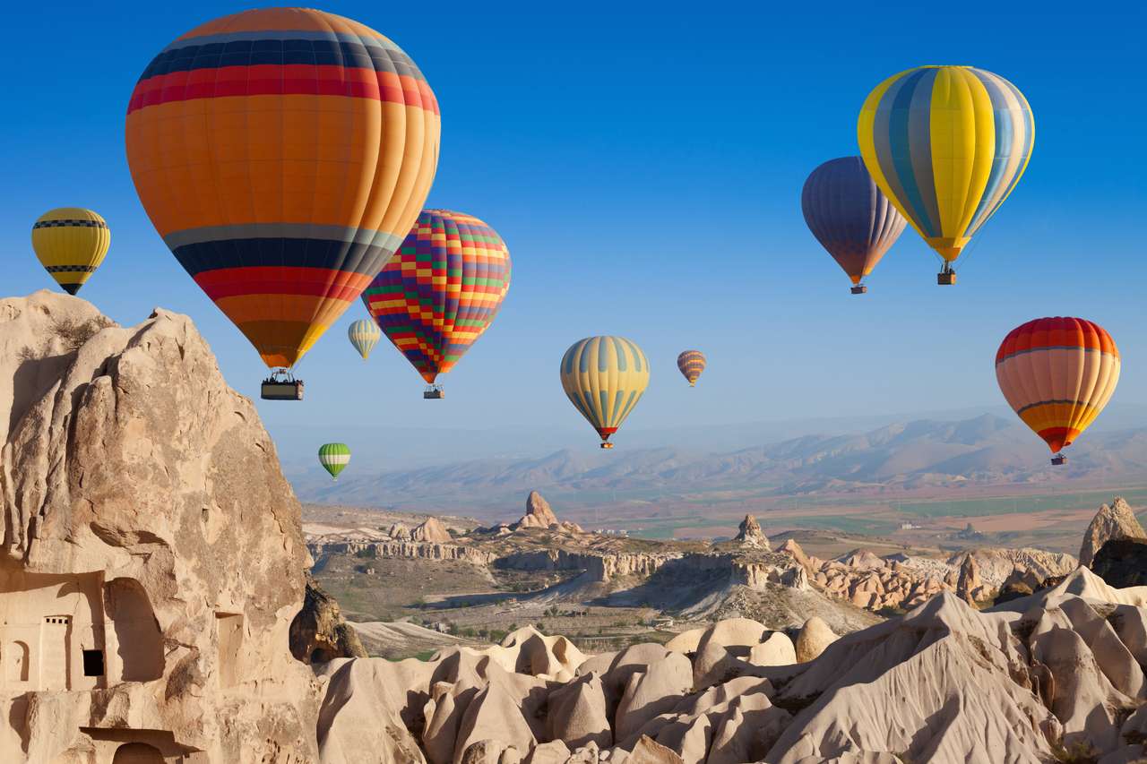 Attrazione incredibile - mongolfiere che volano sopra il paesaggio roccioso insolito in Cappadocia, Turchia puzzle online