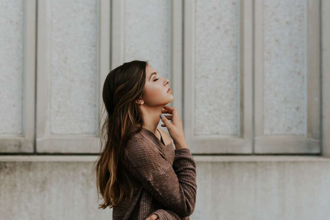 vrouw in bruine top met lange mouwen die naast de muur staat online puzzel