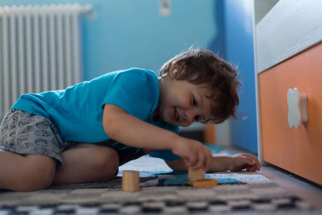 dívka v modrém tričku hraje s hnědou dřevěnou deskovou hrou online puzzle