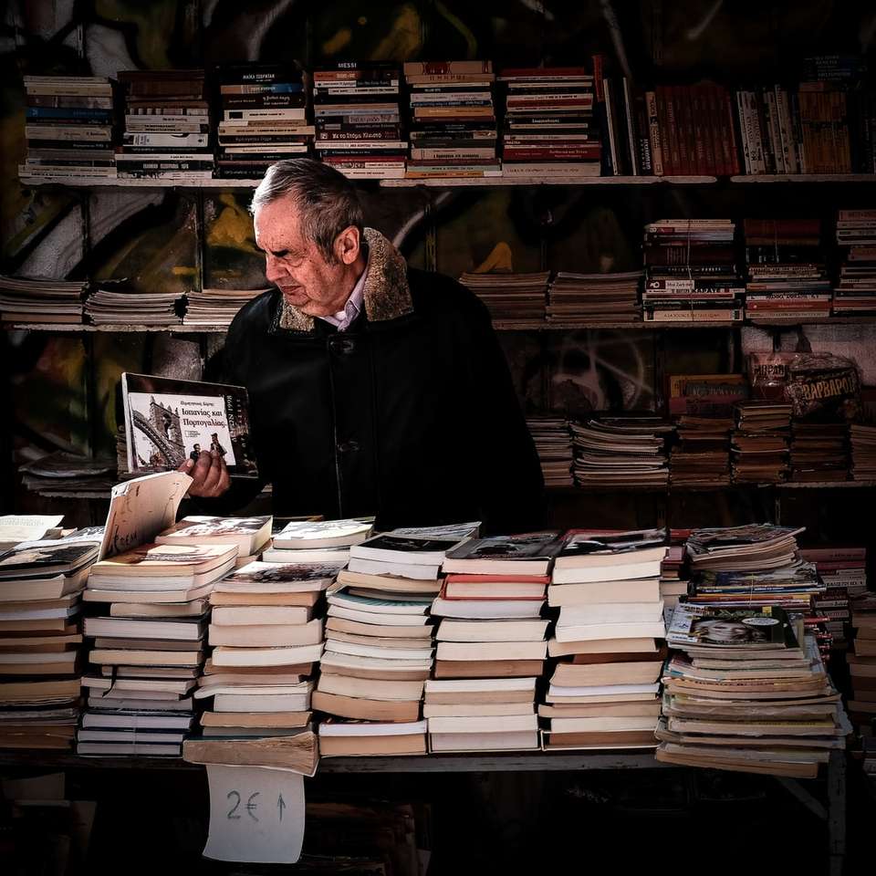 Mann hält Buch in der Nähe der Bibliothek Puzzlespiel online