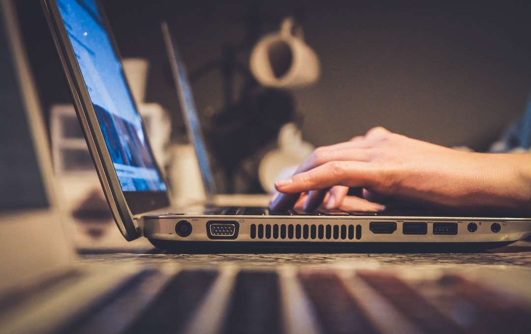 човек, използващ сребърен лаптоп на бюрото онлайн пъзел