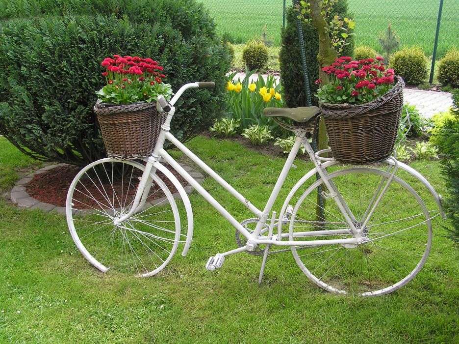 Bicicleta decorada con flores en el jardín. rompecabezas en línea