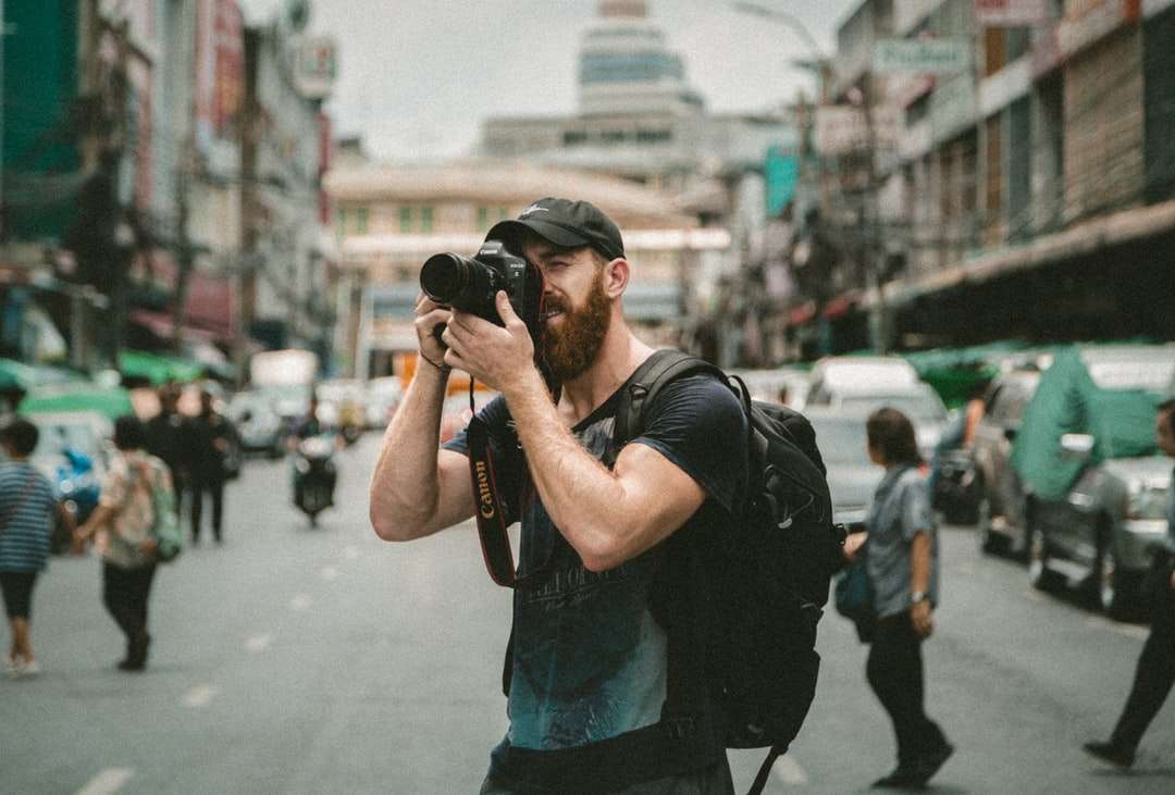 fotografering av en man med en DSLR-kamera med grunt fokus pussel på nätet